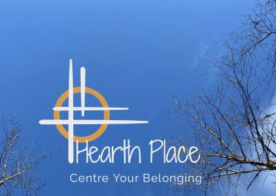 Photo of blue sky with silhouettes of tall majestic trees with Hearth Place logo and Centre Your Belonging tagline overtop