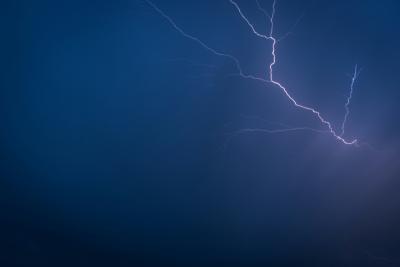 lightening strike alights a dark blue sky