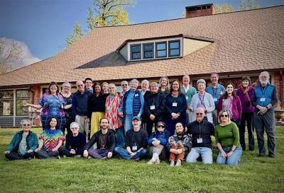 Group of Focusers posing together on grass in front of a cabin.