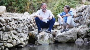 A picture of the facilitators Dana and Baruch sitting by a stream of water