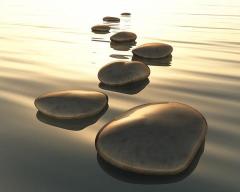 Honoring Milestones Logo - stones in a body of water